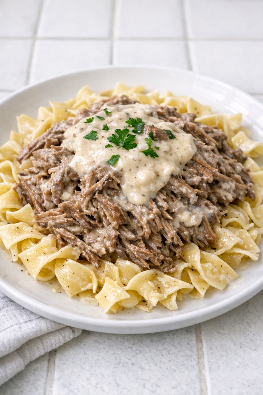 Creamy shredded beef plated with noodles