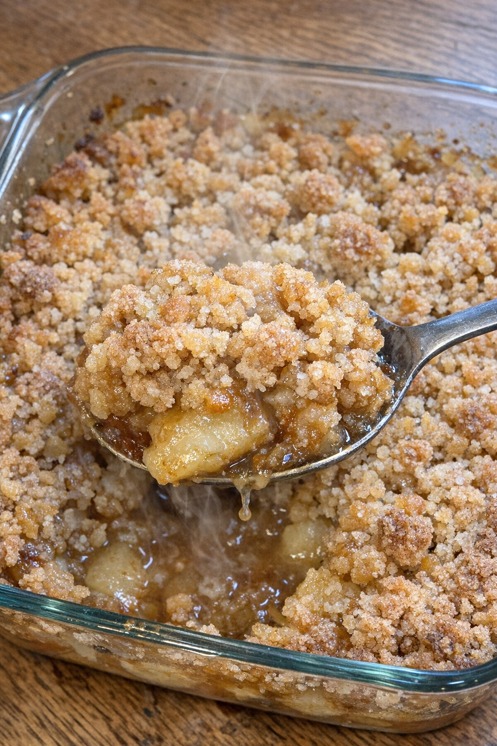 Baked apples with golden crumb topping in a glass casserole dish