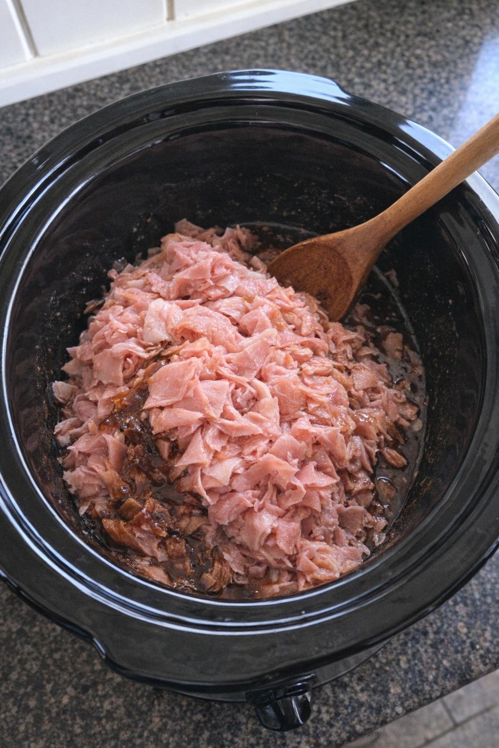 Shaved ham in a slow cooker with dark glaze