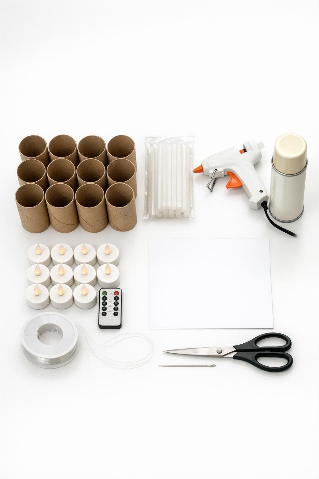 Materials for making paper roll candle decorations laid out on a white table