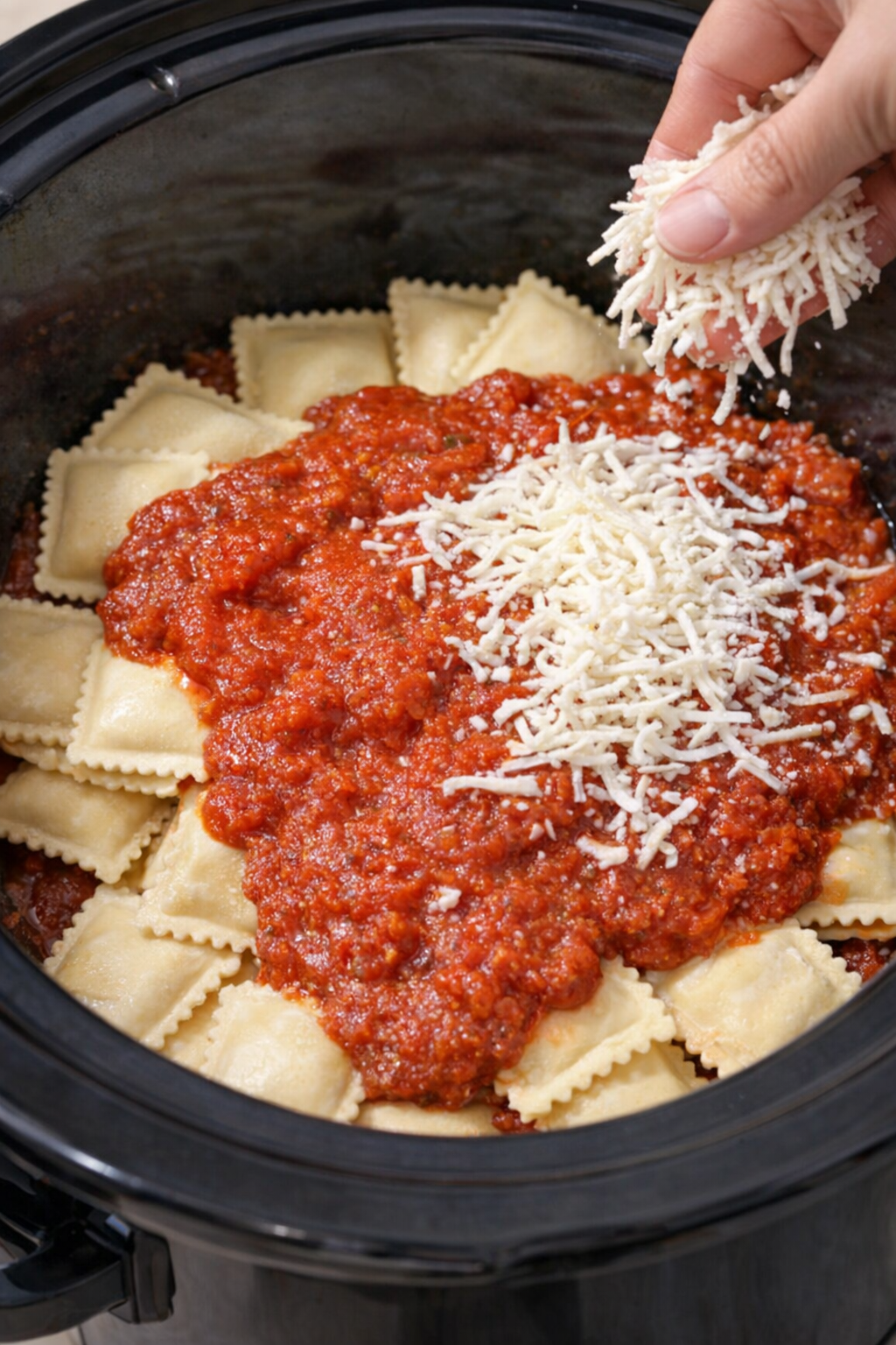 Layering ravioli sauce and mozzarella in the slow cooker
