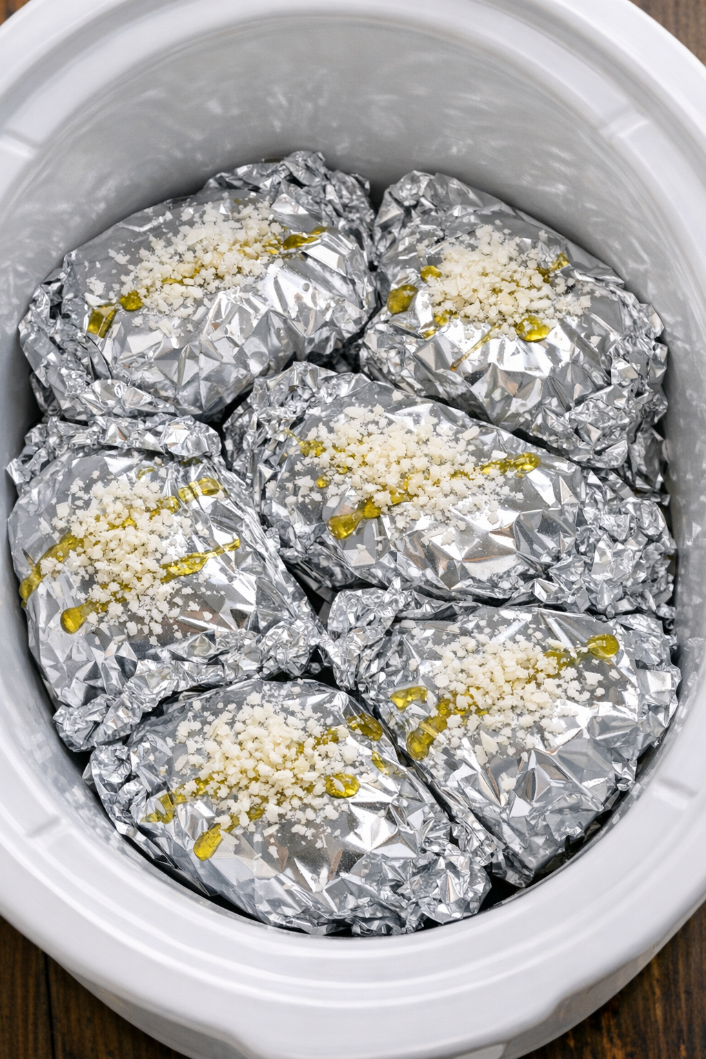 Slow cooker foil pasta packets in a white slow cooker