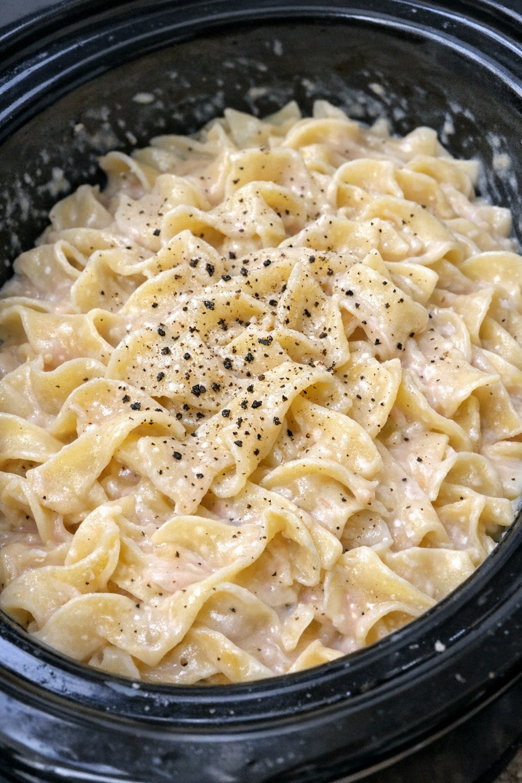 Slow cooker Amish horseradish cream noodles in a black slow cooker