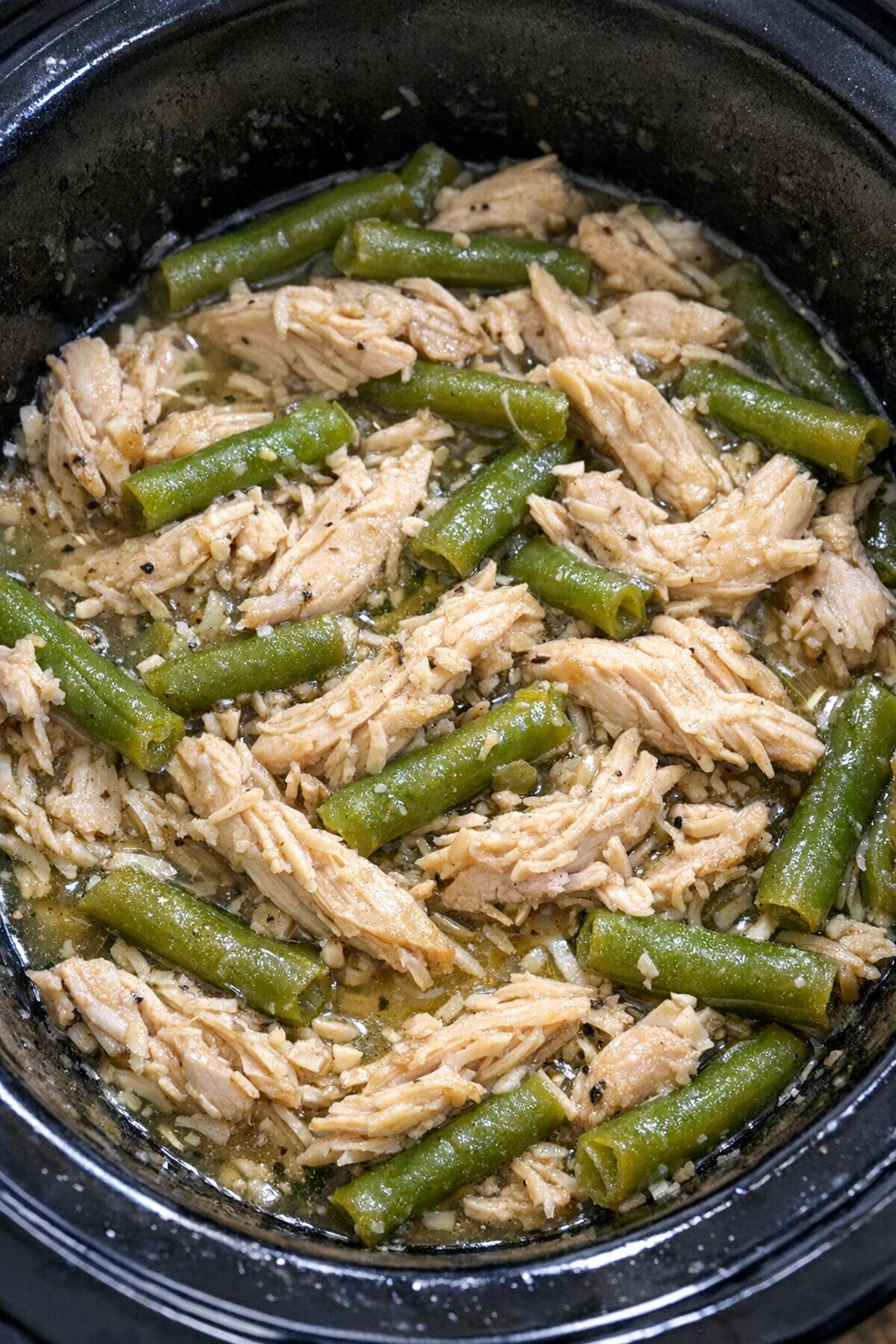 Slow cooker chicken and green beans in a black slow cooker