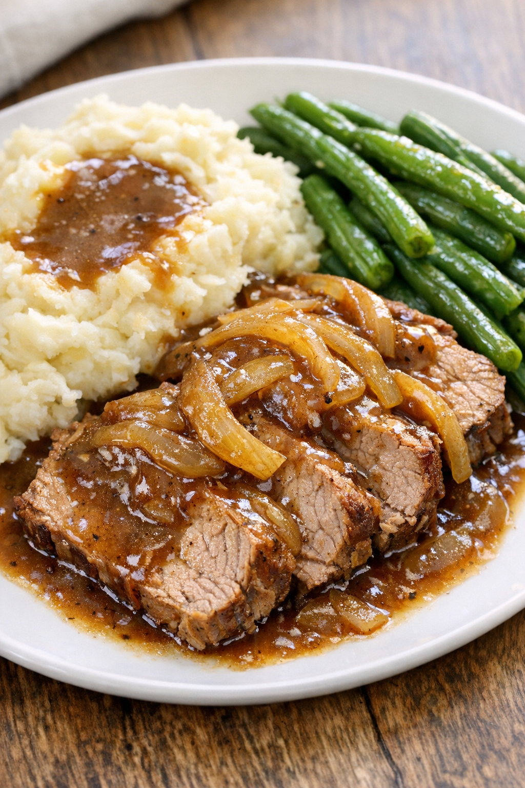 Sliced pork roast served with gravy and sides