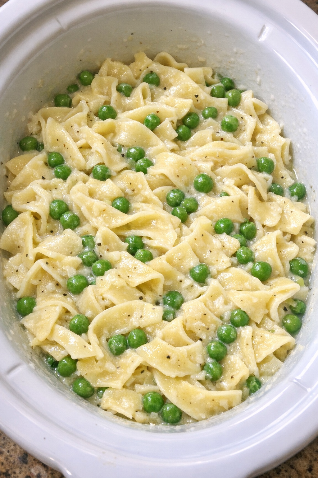 Slow cooker Amish pea noodles in a white slow cooker