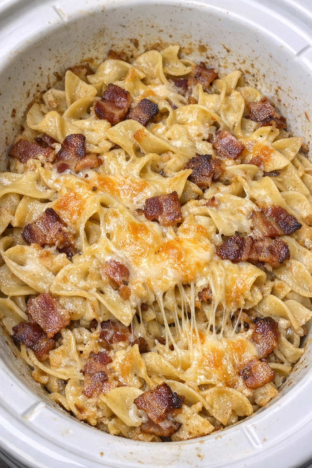 Slow cooker Amish bacon noodle bake in a white slow cooker
