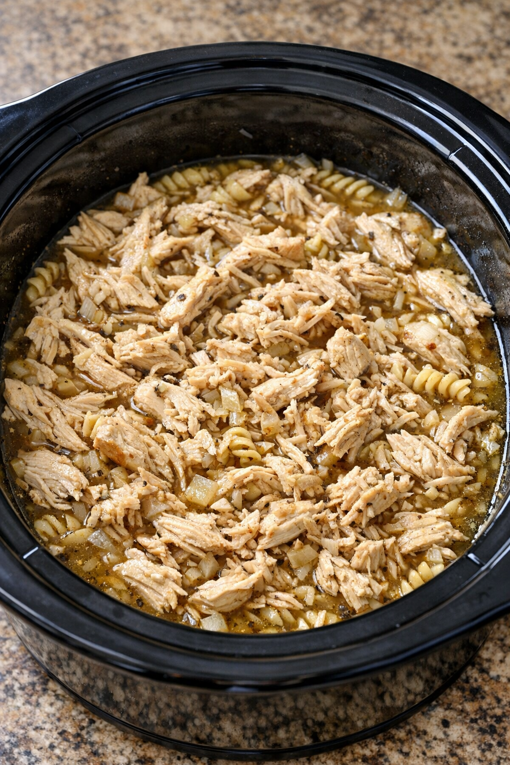 Shredded chicken returned to the slow cooker broth