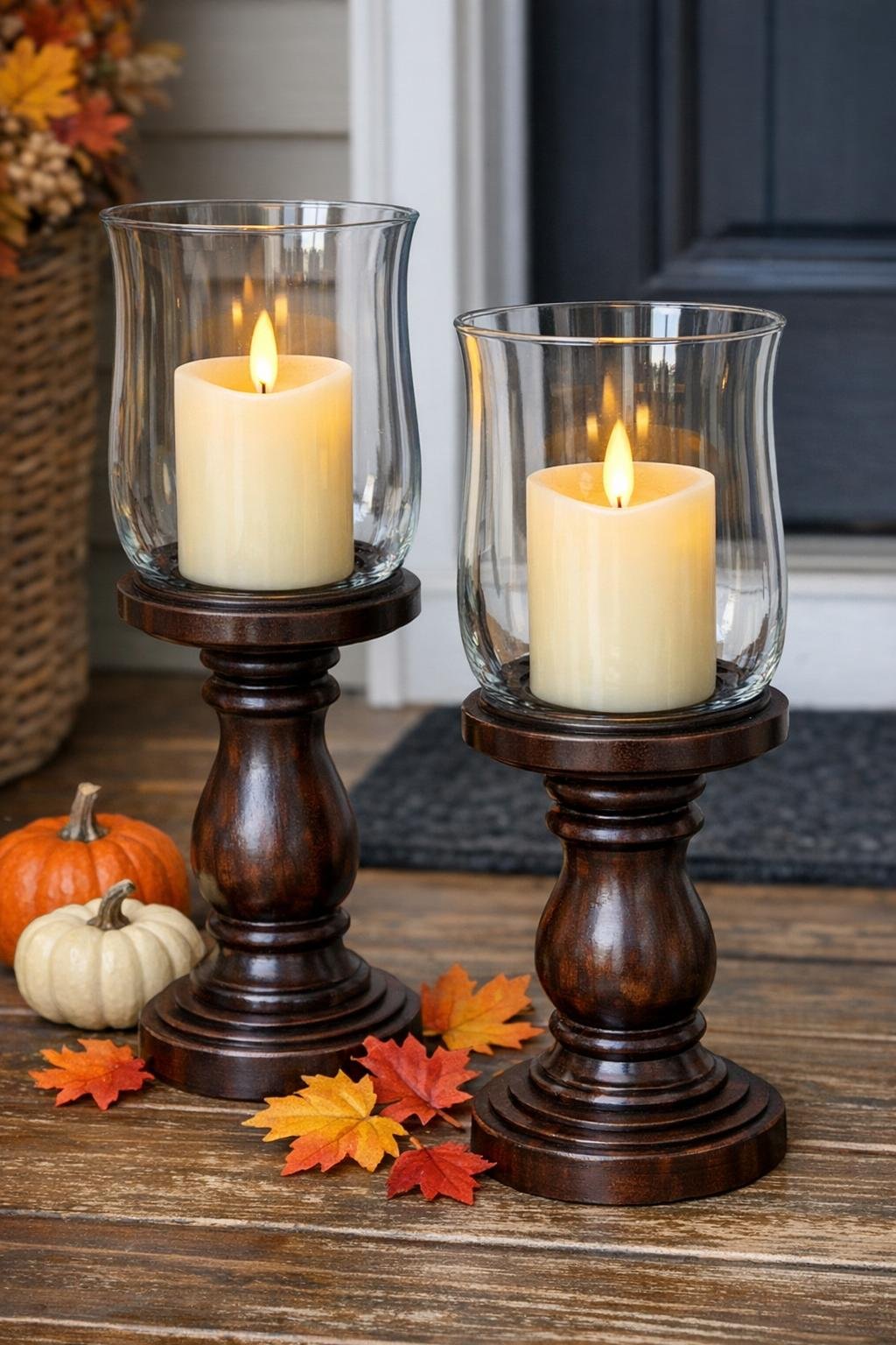 Finished autumn lanterns made from glass hurricane holders on wooden candlesticks styled for a front porch